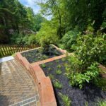 Apex Outdoors landscaped pathway with stone walls and greenery