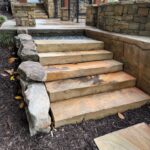 Finished outdoor stone steps and retaining wall by Apex Outdoors