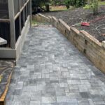 Apex Outdoors alley renovation with clean stone wall and walkway