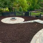 Backyard patio with fire pit built by Apex Outdoors in stylish stonework